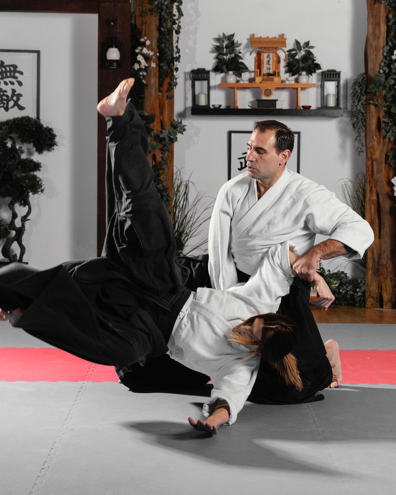 Aïkidoka en hakama exécutant une projection sur son partenaire, en plein mouvement